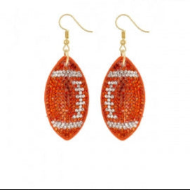 Football-shaped earrings with rhinestone details on a white background