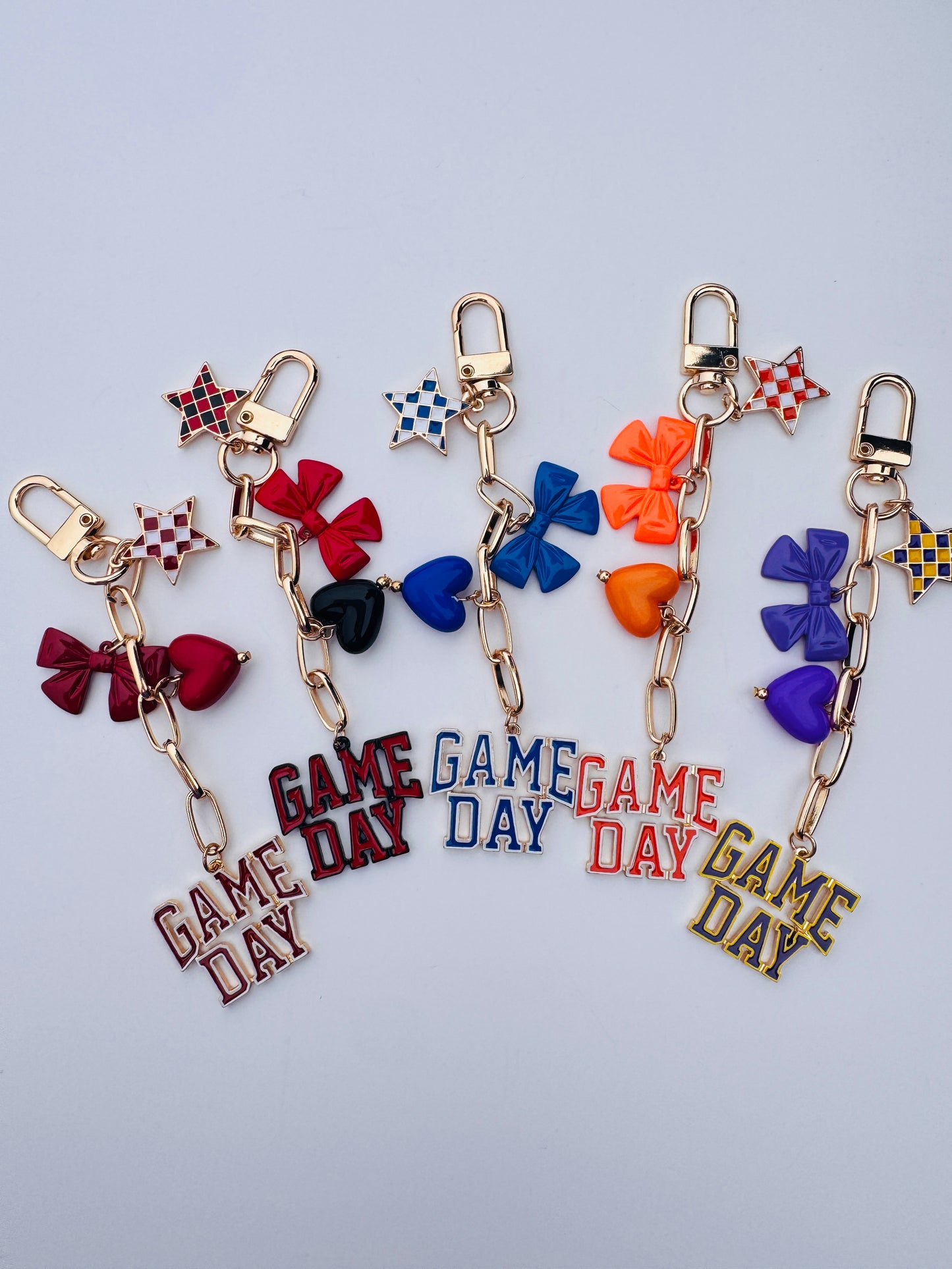 Set of colorful keychains with 'GAME DAY' charms on a light gray background