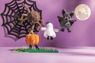 Four Halloween plush toys: brown spider, orange pumpkin, white ghost, and gray bat