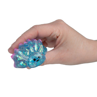 Hand squeezing a glittery blue translucent sea slug squishy toy with spiky edges