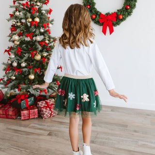 Girl wearing green sequin Christmas tutu skirt with gingerbread and snowflake appliqués