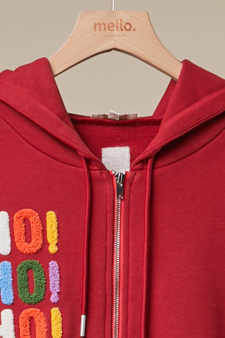 Red zip-up hoodie with colorful HoHoHo chenille patches on a wooden hanger