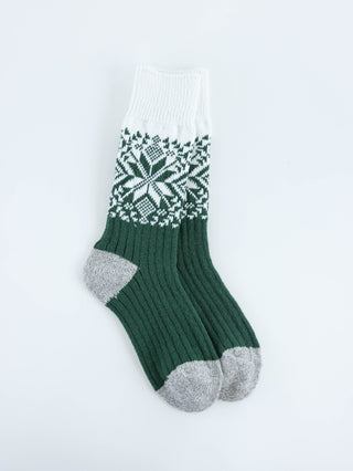 Green and white patterned sock on a light gray background