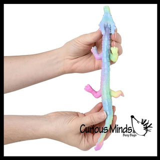 Colorful squishy toy held by two hands with 'Curious Minds Busy Bags' branding.