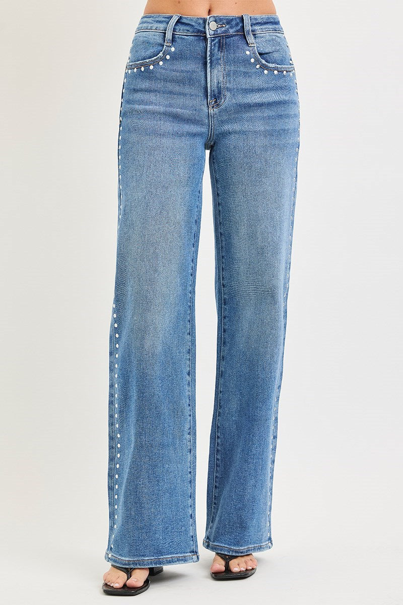 Blue jeans with decorative studs on a light gray background