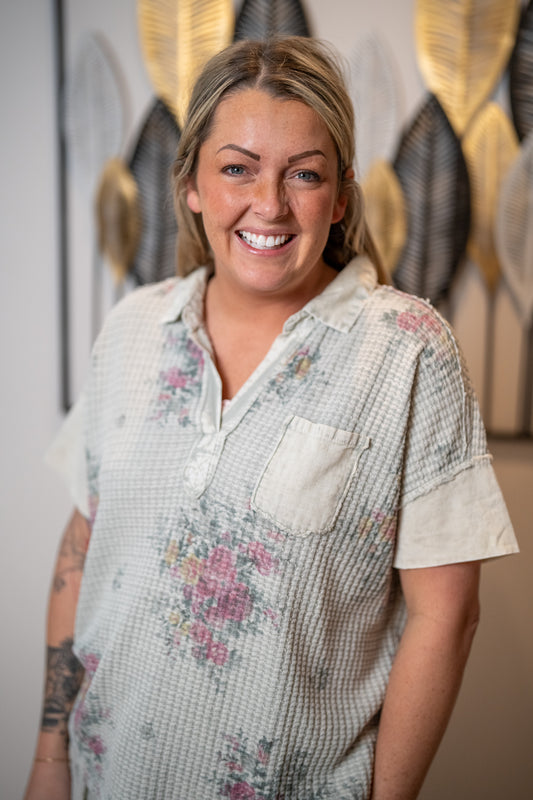 woman wearing waffle ash grey light floral top with pocket detail v neck and collar