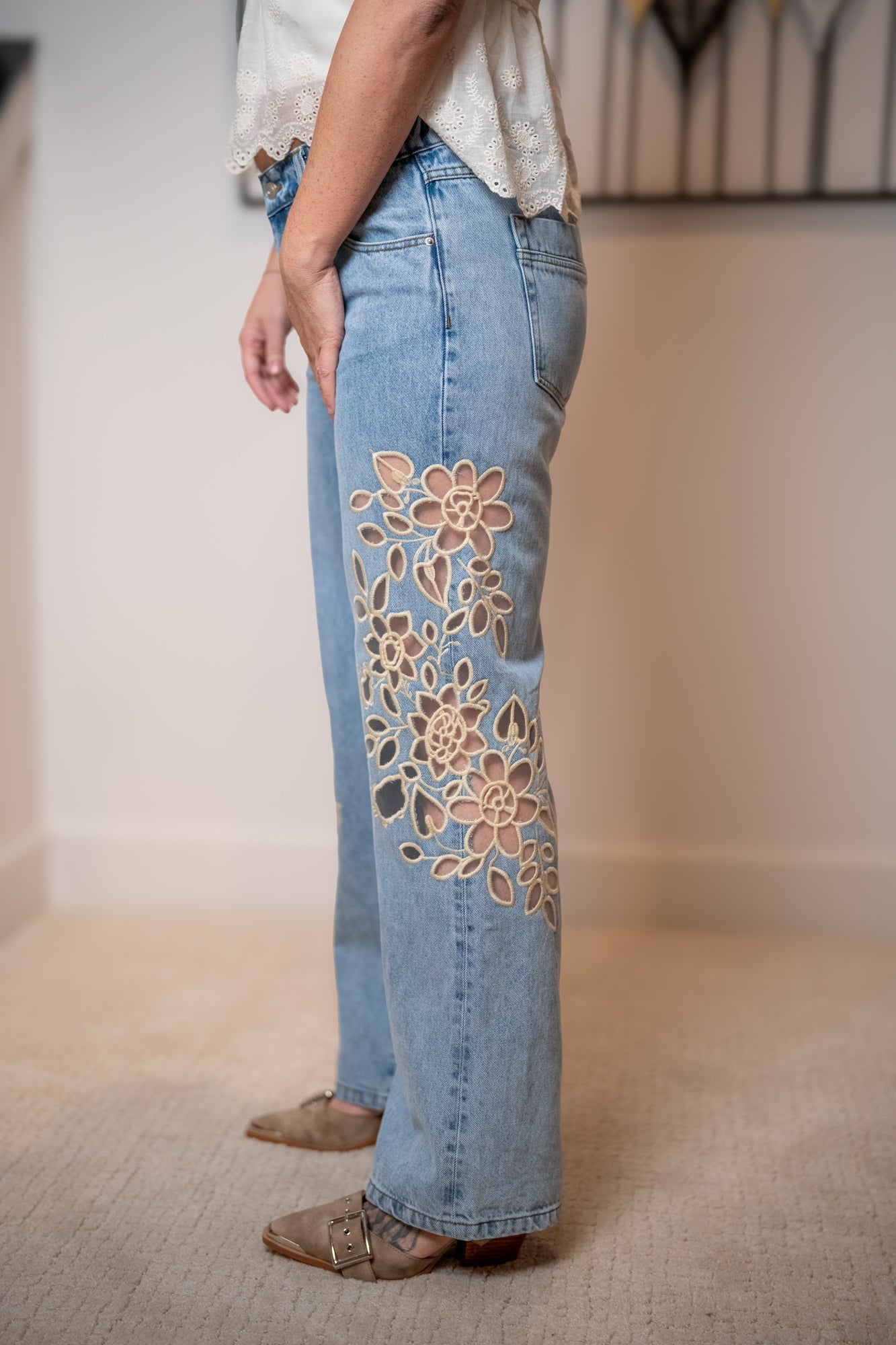 close up for the floral lace cut out detail on the light wash denim