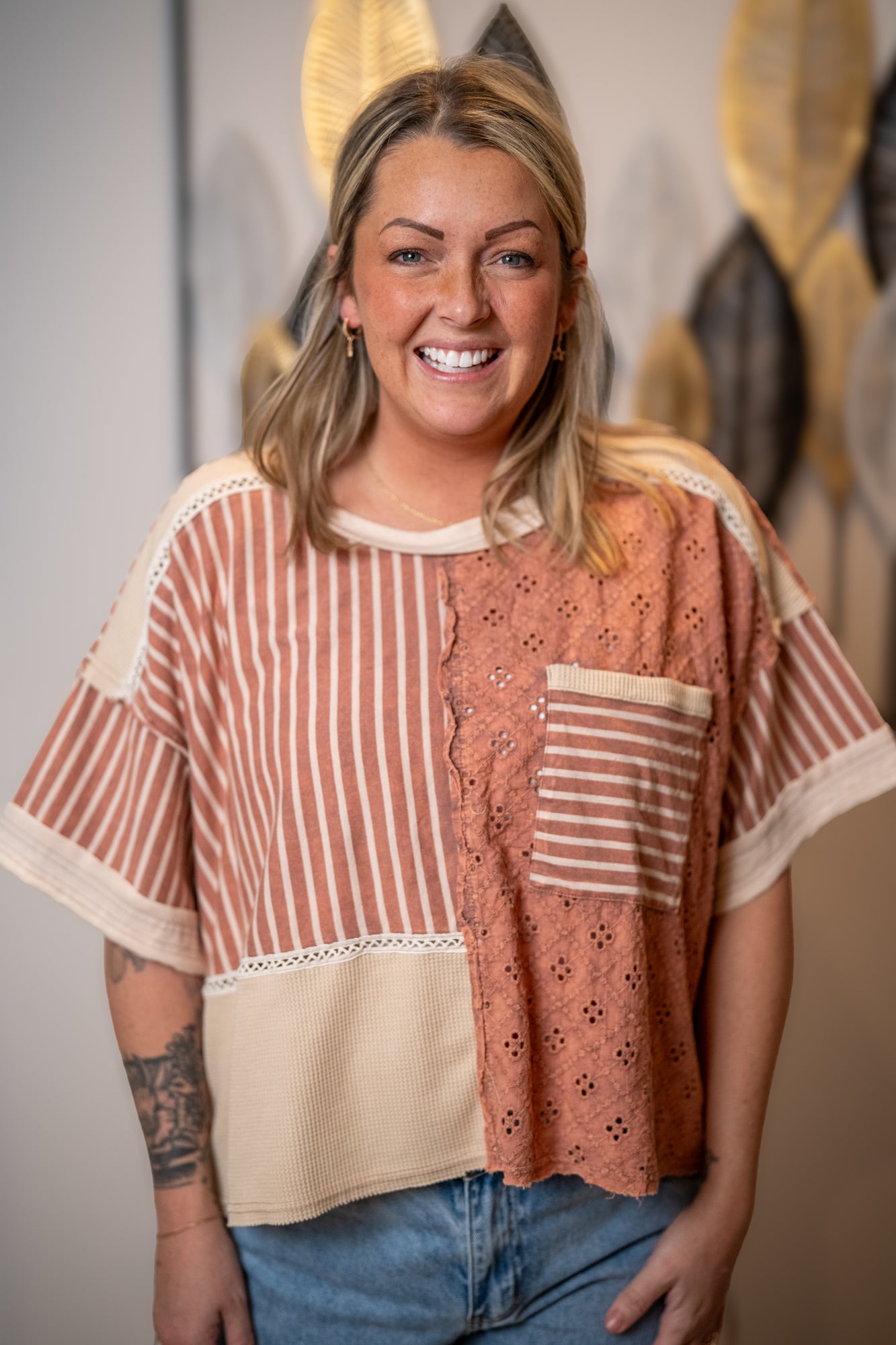 Close up of top with lace up details, stripes, and textured fabric mix