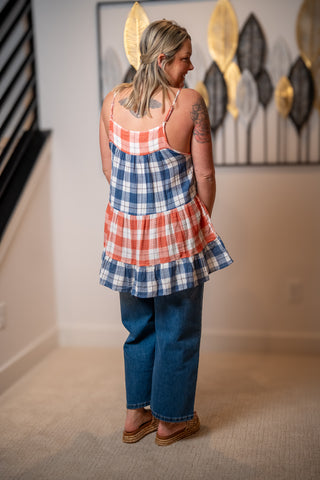Woman wearing a plaid tunic tank top with adjustable straps