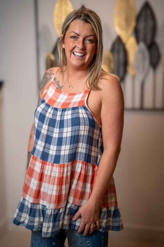 Woman wearing a red and white plaid tank top that is tiered and flowy