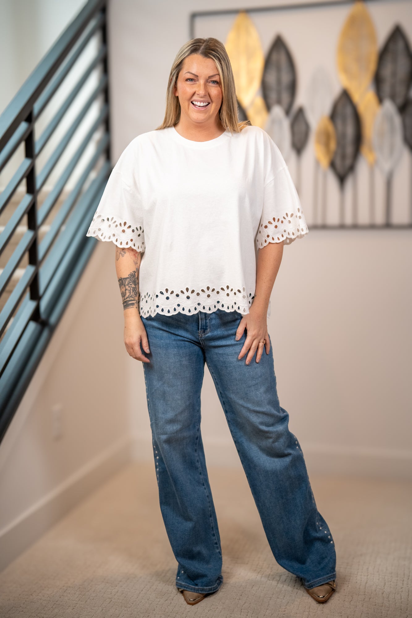 Easel white eyelet embroidered hem top with scalloped trim and loose silhouette paired with medium washed denim