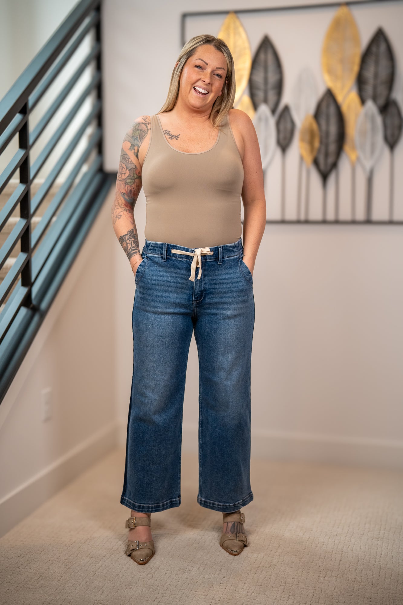Risen elastic band high rise cropped wide leg jeans with drawstring waist front view styled with tan tank top