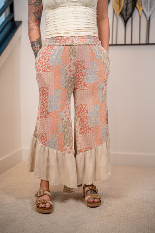 close up of the multi color floral pattern bottoms with cream ruffle detail on bottom