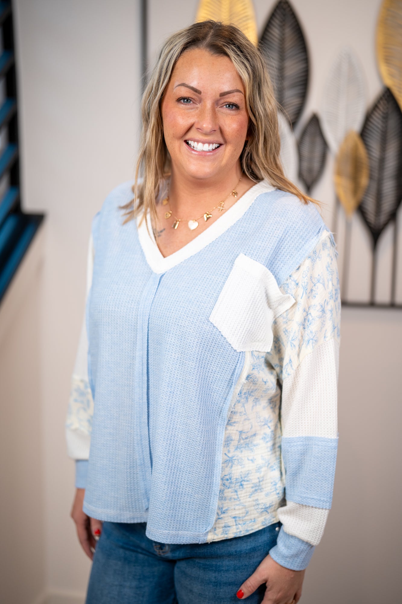 Waffle knit long sleeve top with floral patchwork sleeves and front pocket in light blue