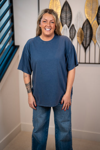 Person wearing a navy blue oversized t-shirt and jeans 