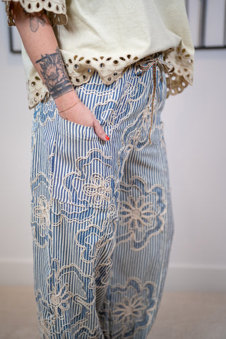 Model wearing Easel striped embroidered wide leg pants with drawstring waist and relaxed fit hand in pocket
