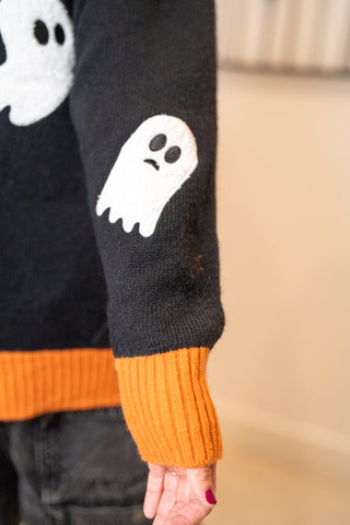 Black Halloween sweater with white ghost patch on sleeve and orange cuffs