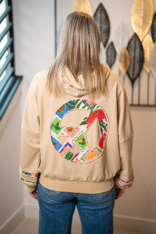 Tan hoodie sweatshirt with colorful patchwork peace sign graphic on back