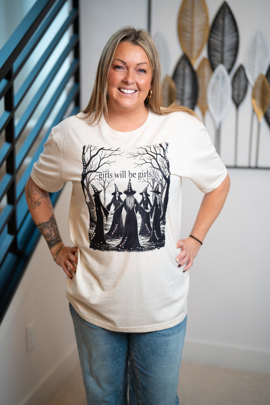 Woman wearing a white t-shirt with a graphic design, standing indoors.