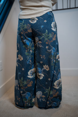 Blue floral-patterned pants worn by a person indoors.