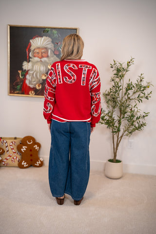 Red Christmas sweatshirt with plaid back lettering, shown with wide-leg jeans