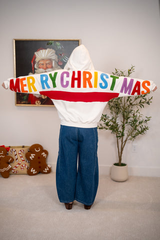 White zip-up hoodie with colorful Merry Christmas letters across the sleeves and back
