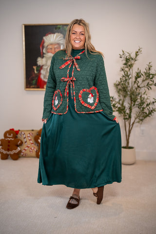 Green quilted jacket with plaid trim, bow closure, and Santa heart pockets