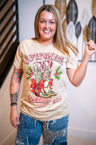 Woman wearing a 'Cowgirl Christmas' themed t-shirt with graphic design.