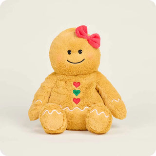 Golden brown gingerbread girl plush toy with pink bow, heart buttons, and white icing trim