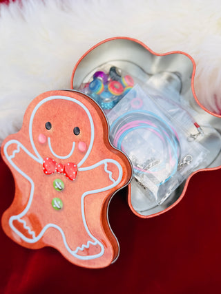 Gingerbread man-shaped cookie cutter with a clear container inside on a red surface.