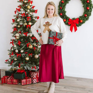 Cream sweatshirt with gold sequin gingerbread man patch worn with red satin skirt