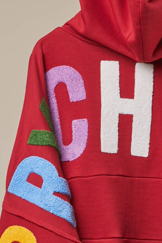 Red zip-up hoodie with colorful chenille letter patches on back and sleeve