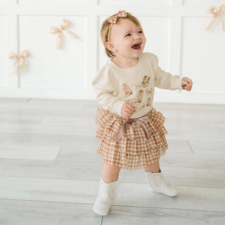 Toddler girl wearing rust gingham tiered tutu skirt with satin bow tie